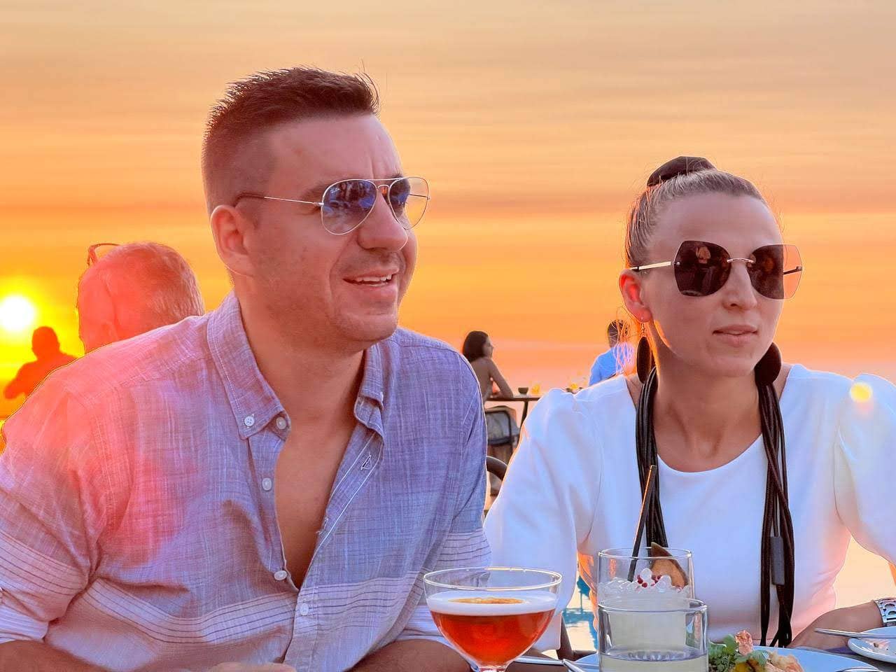 Stan and his wife Petya at a restaurant by the sea at sunset.