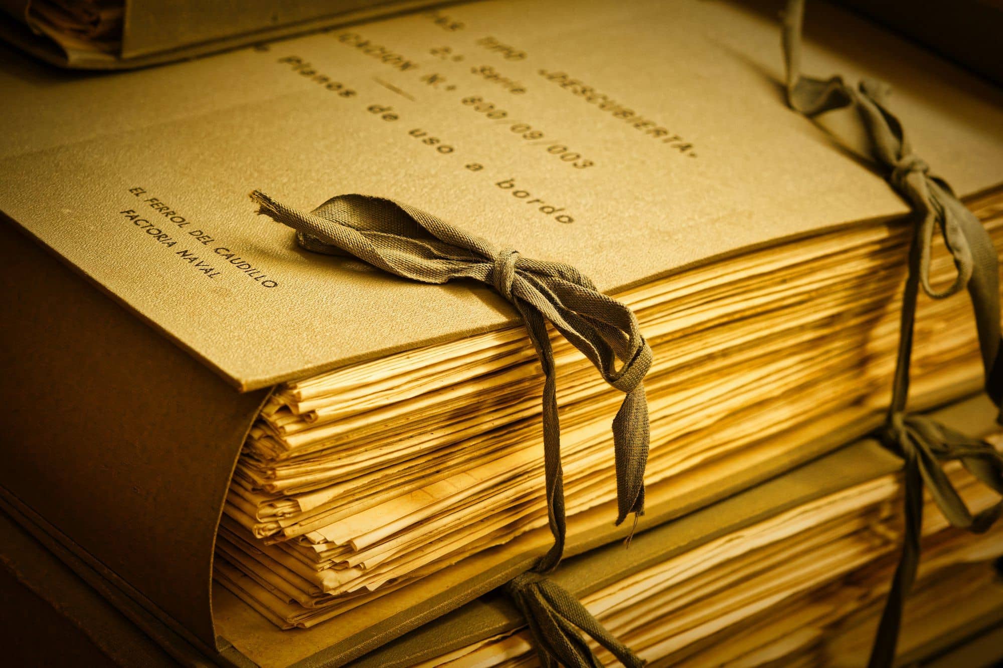 Stacks of tied documents in warm light.